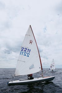 Exciting sailing regatta with vibrant sailboats racing across the open sea under a cloudy sky.